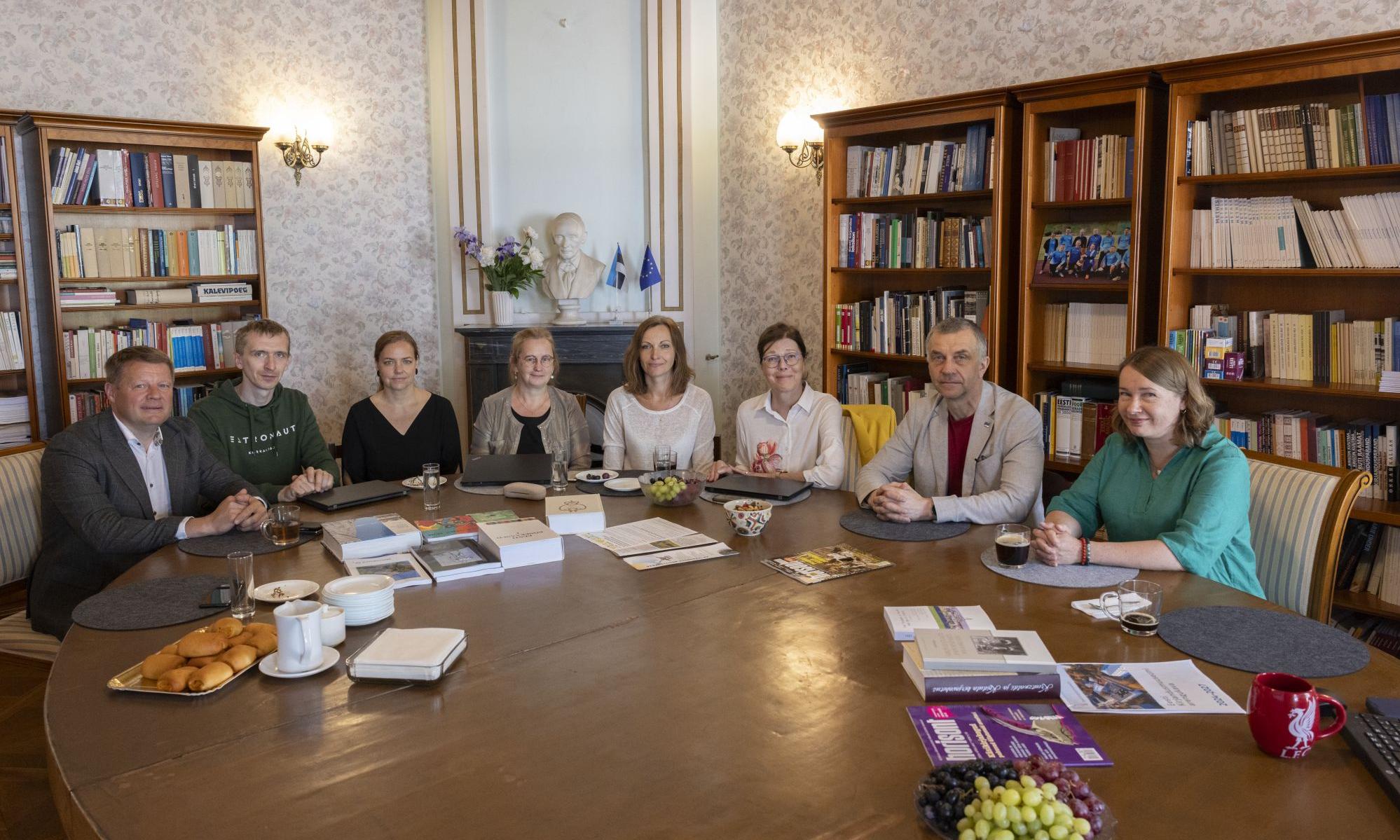 Kohtumisel osalejad Tartu rahu laua taga kaminasaalis
